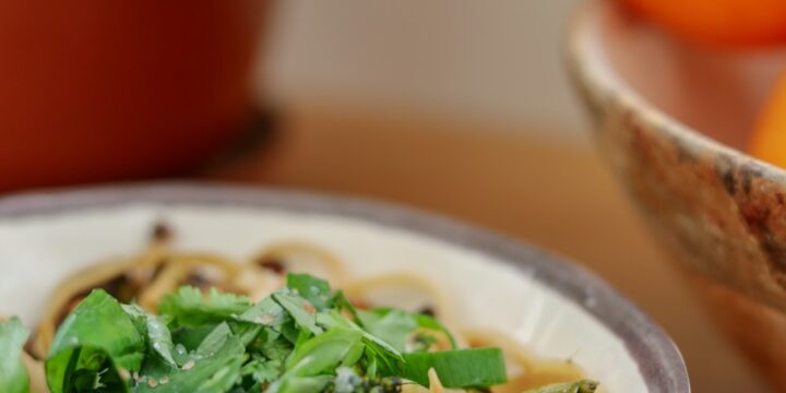 pasta with green leaf vegetable on white ceramic plate