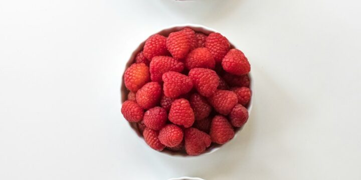 red and black berries on white surface